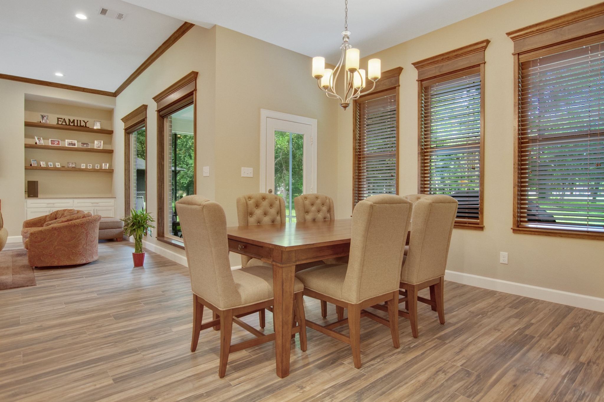 Everline Homes dining room with wood trim, a chandelier and a wall of windows