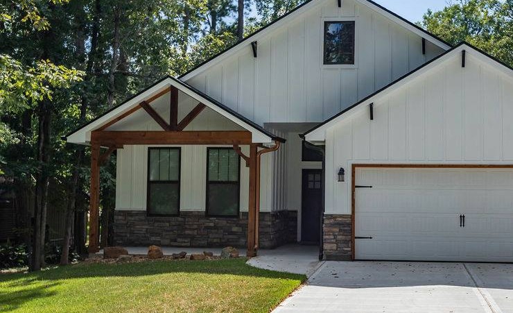 Everline Homes modern farmhouse exterior with board and batten siding, timber porch brackets and stone accents